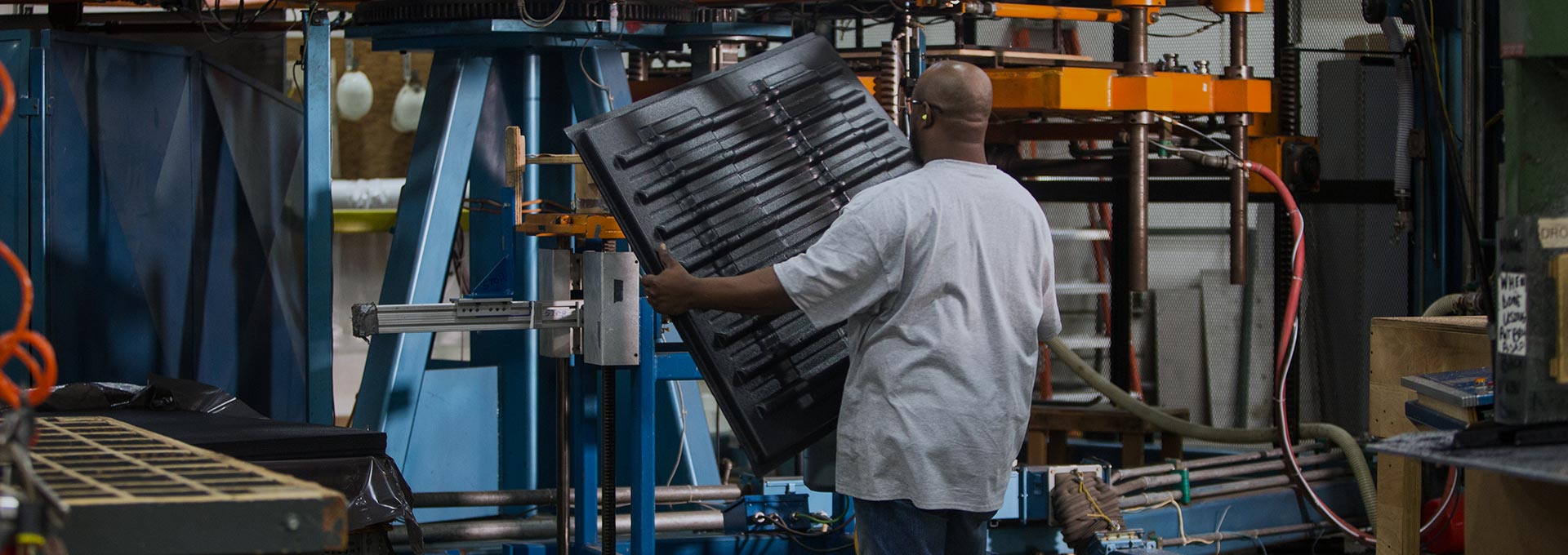 worker holding vacuum formed plastic sheet